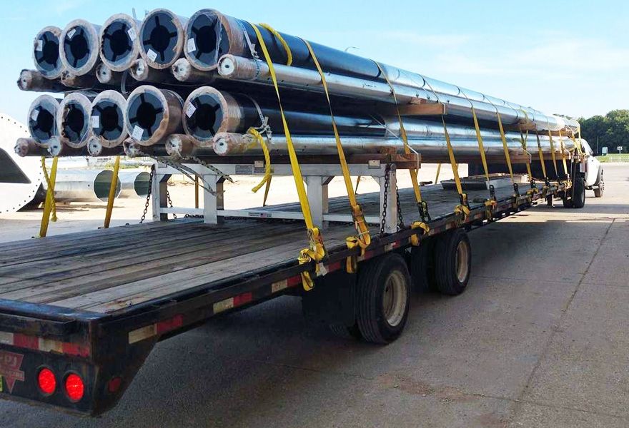 step deck trailer carrying load of pipes