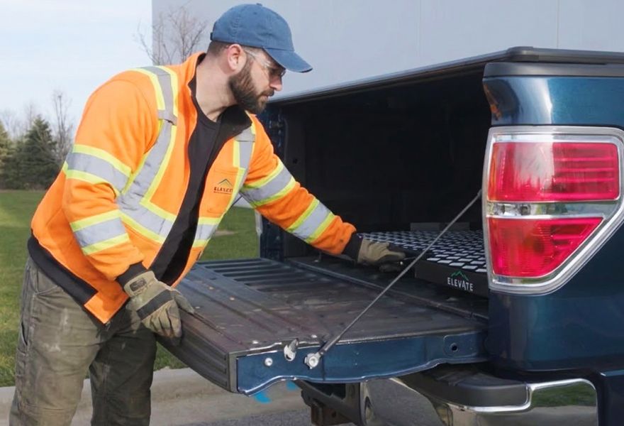 Man sliding out the Elevate Outdoor truck bed tray