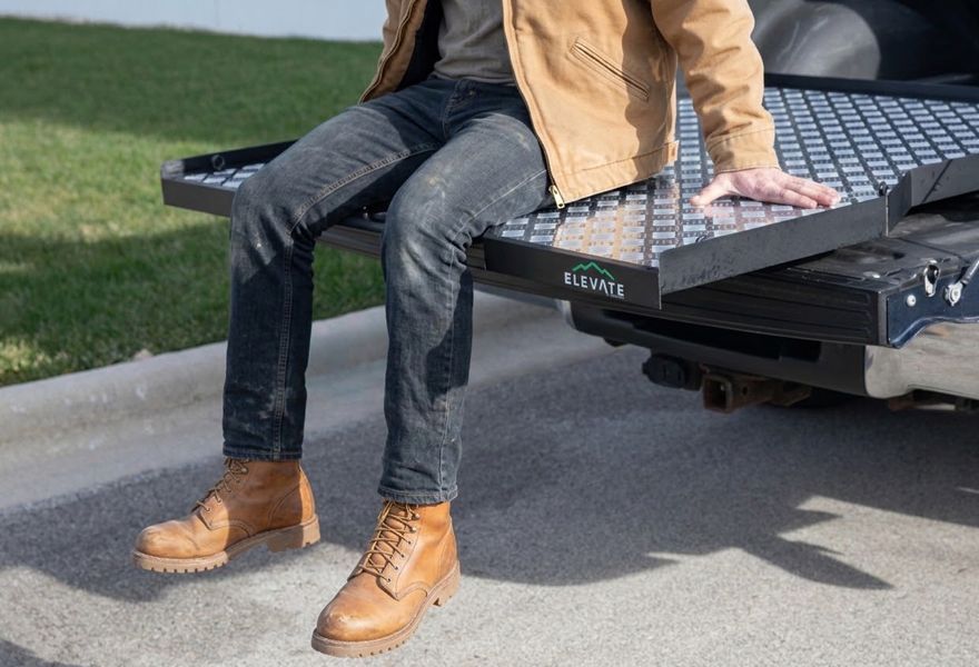Man sitting on Elevate Outdoor slide-out truck bed tray