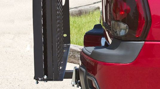Carrier folds up against vehicle when not in use