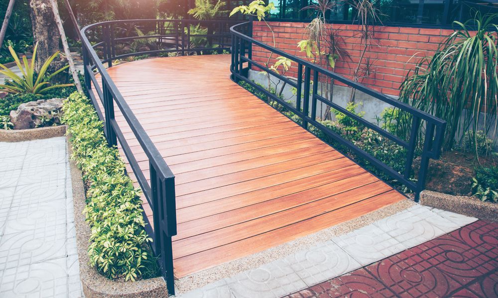 wooden wheelchair ramp with handrails shown outside a commercial building