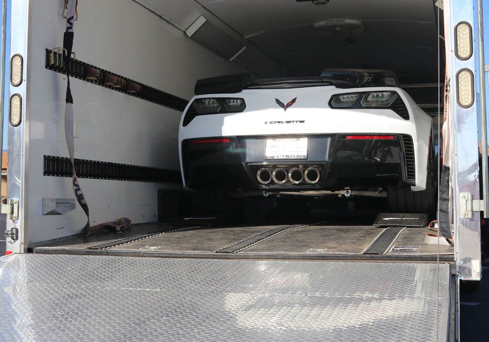 white corvette on Race Ramps trailer mates in an enclosed trailer with E-track
