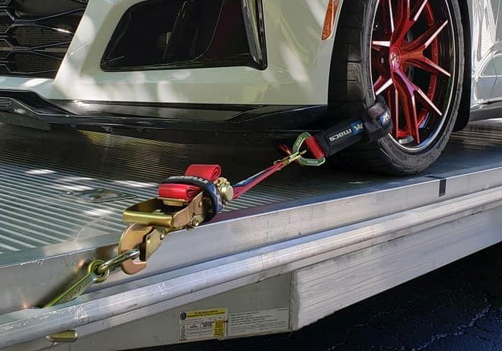 car secured to aluminum trailer with 2 inch Mac's ratchet strap