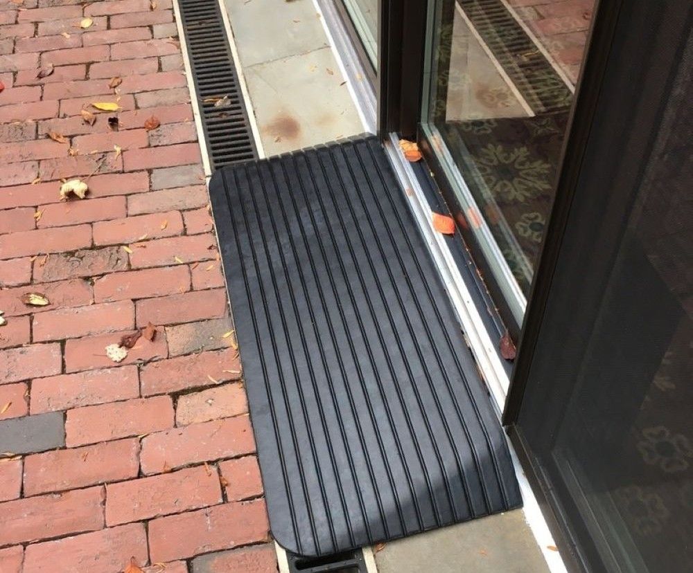 Rubber threshold ramp bridging doorway lip