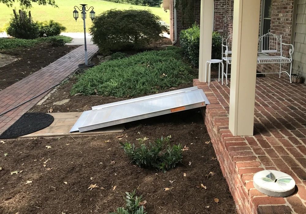 Wheelchair ramp bridging an outdoor patio and a pathway