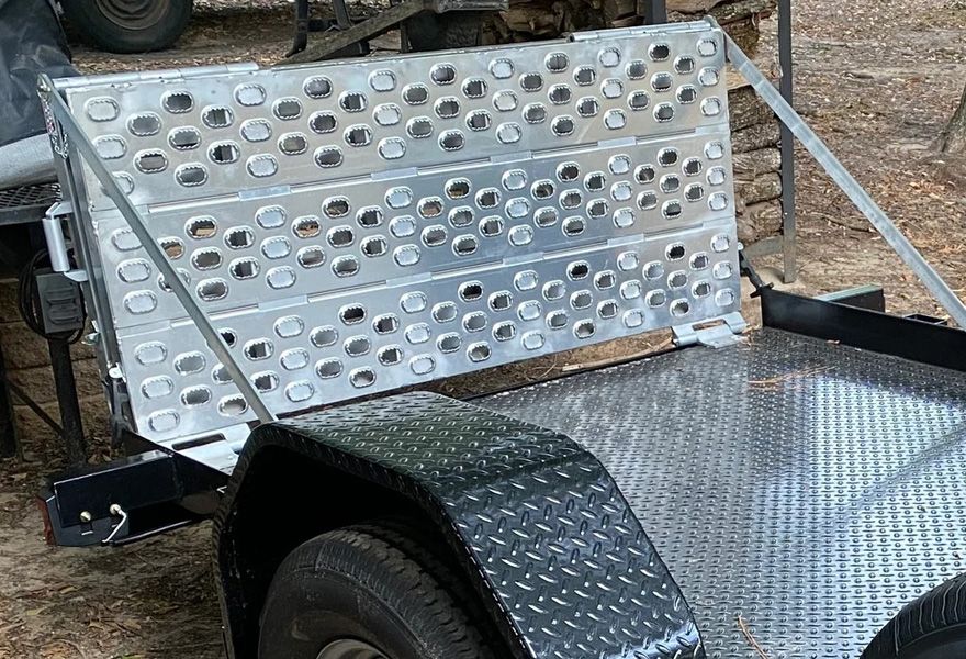 Bi-fold trailer ramp on a trailer