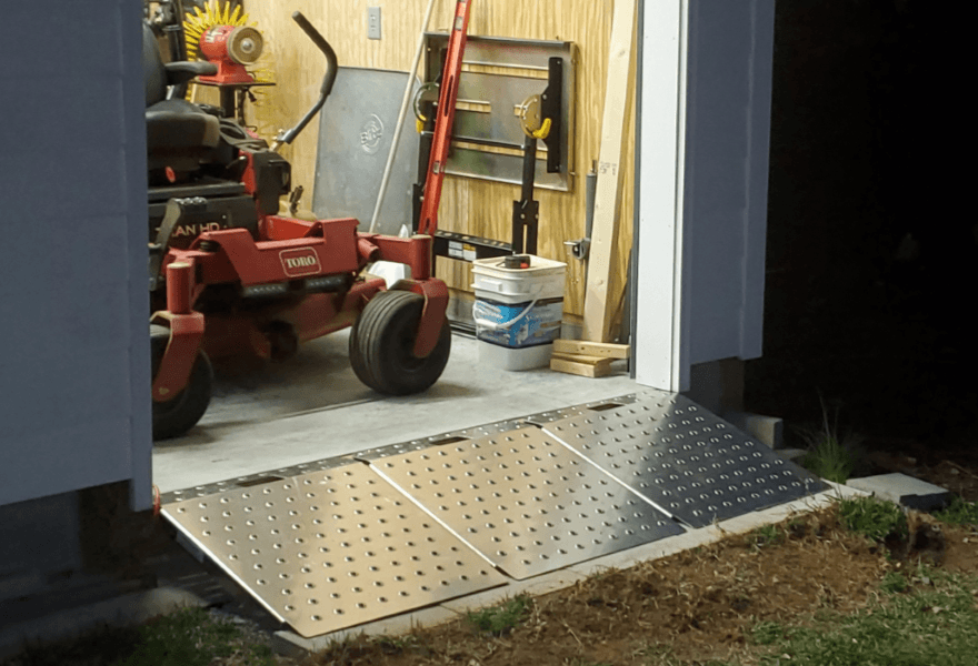 Two aluminum shed ramps positioned for loading equipment